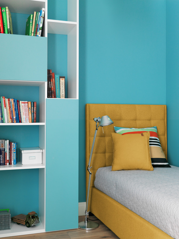 Idée de décoration pour une chambre d'enfant design avec un mur bleu, un sol en bois brun et un sol marron.