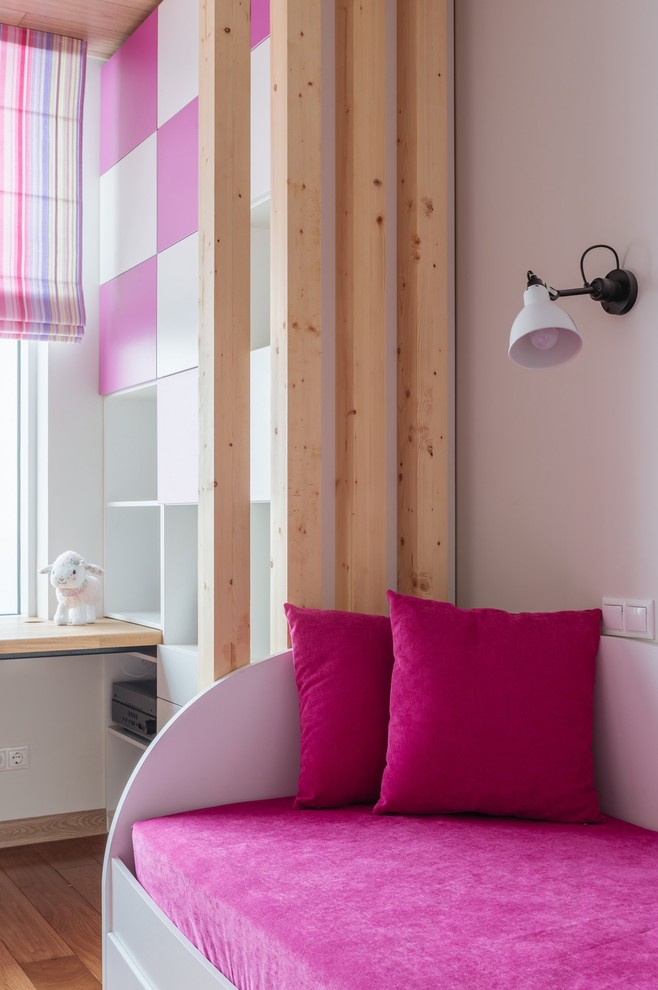 Imagen de dormitorio infantil de 4 a 10 años nórdico grande con paredes blancas y suelo de madera en tonos medios