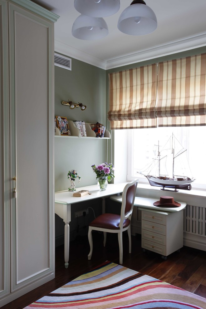 This is an example of a classic kids' study space for boys in Moscow with green walls, dark hardwood flooring and brown floors.