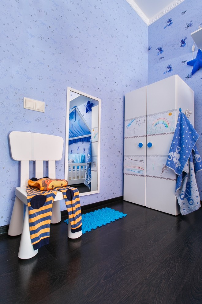 This is an example of a medium sized contemporary toddler’s room for boys in Other with blue walls, laminate floors and brown floors.