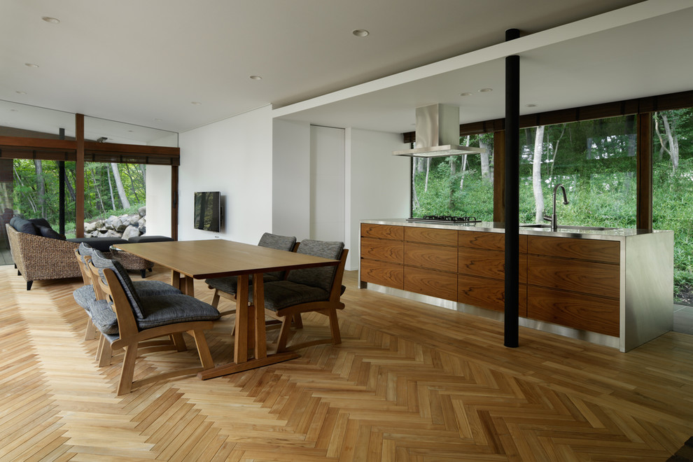 Idee per una sala da pranzo aperta verso il soggiorno chic con pareti bianche, pavimento marrone e parquet chiaro