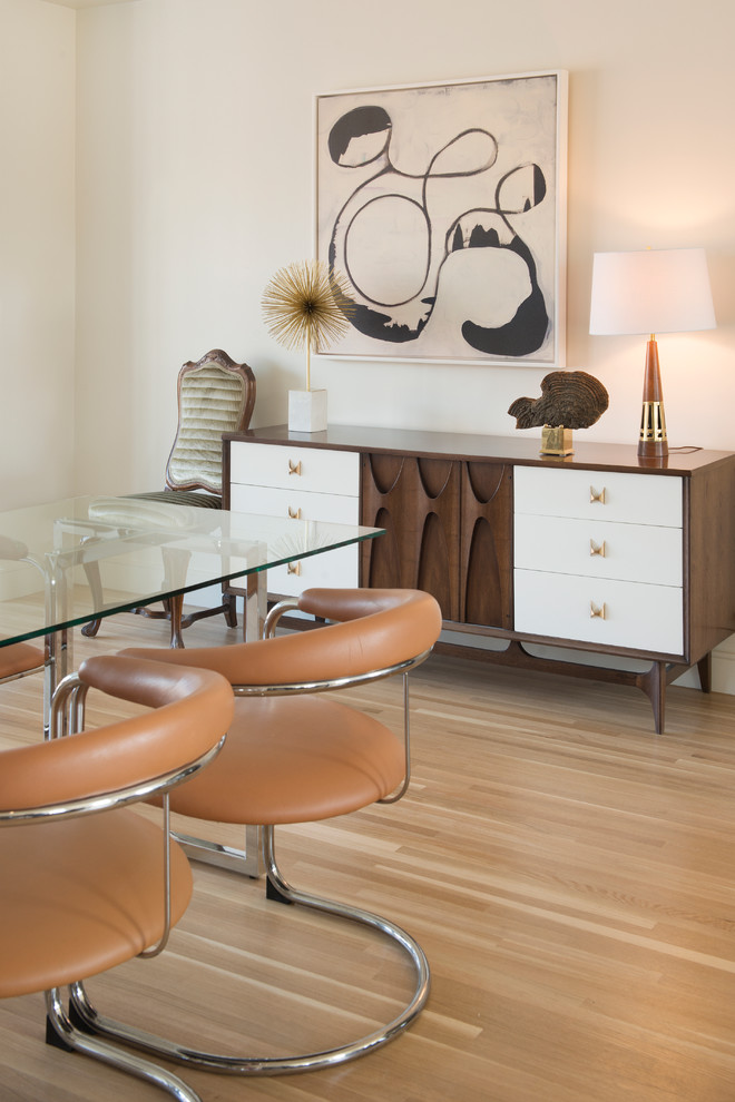 Foto di una grande sala da pranzo aperta verso la cucina minimalista con pareti bianche e pavimento in legno massello medio