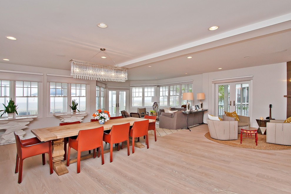 Inspiration for an expansive beach style open plan dining room in New York with white walls and light hardwood flooring.