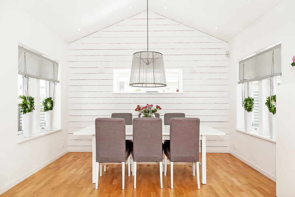 Idée de décoration pour une salle à manger nordique fermée et de taille moyenne avec un mur blanc, parquet clair et aucune cheminée.