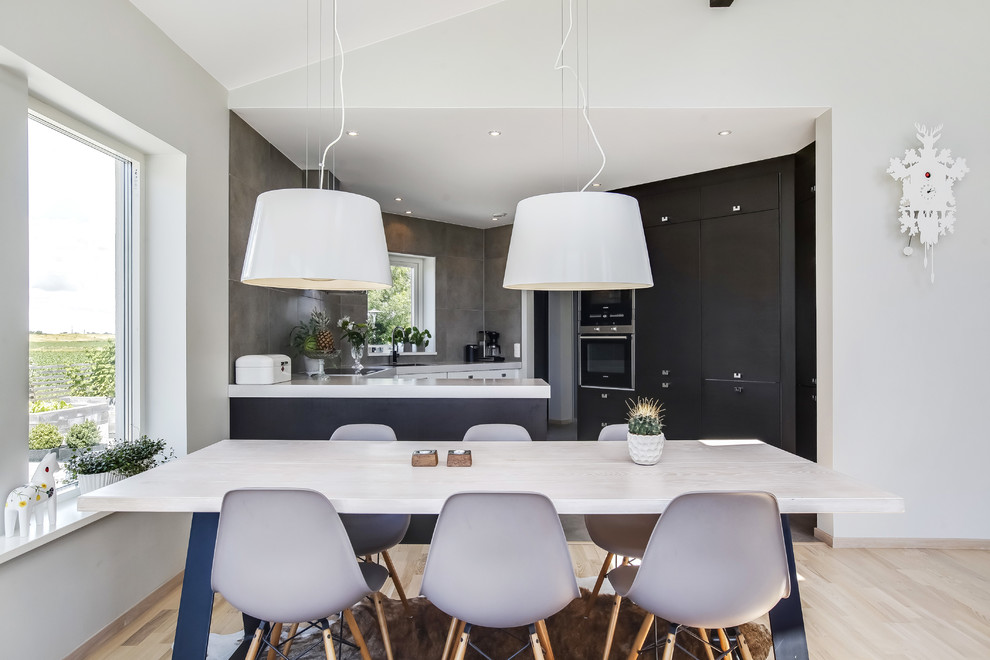 Inredning av ett minimalistiskt mellanstort kök med matplats, med vita väggar och ljust trägolv