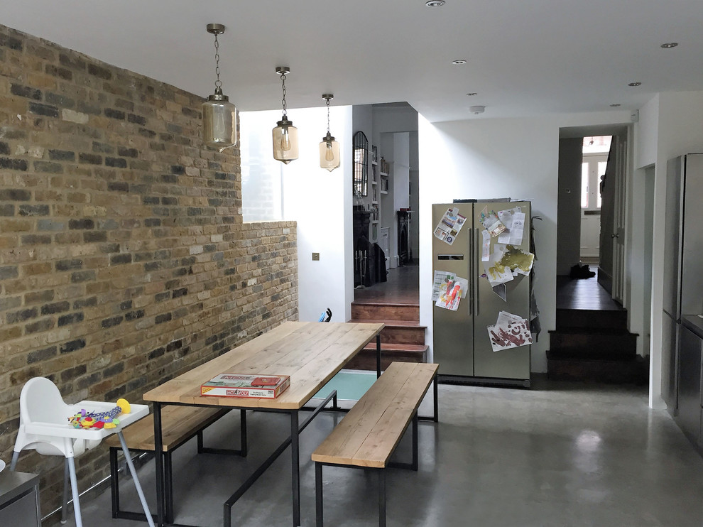 Idee per una sala da pranzo aperta verso il soggiorno design di medie dimensioni con pareti marroni, pavimento in cemento e pavimento grigio