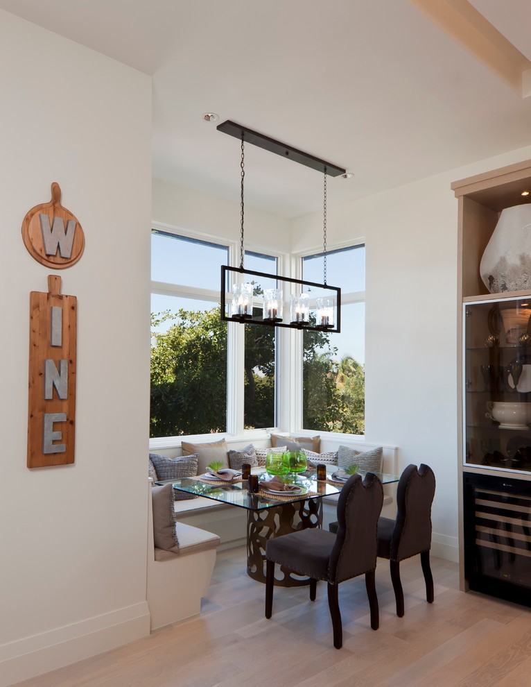 Foto di una sala da pranzo aperta verso la cucina classica con pareti bianche e parquet chiaro