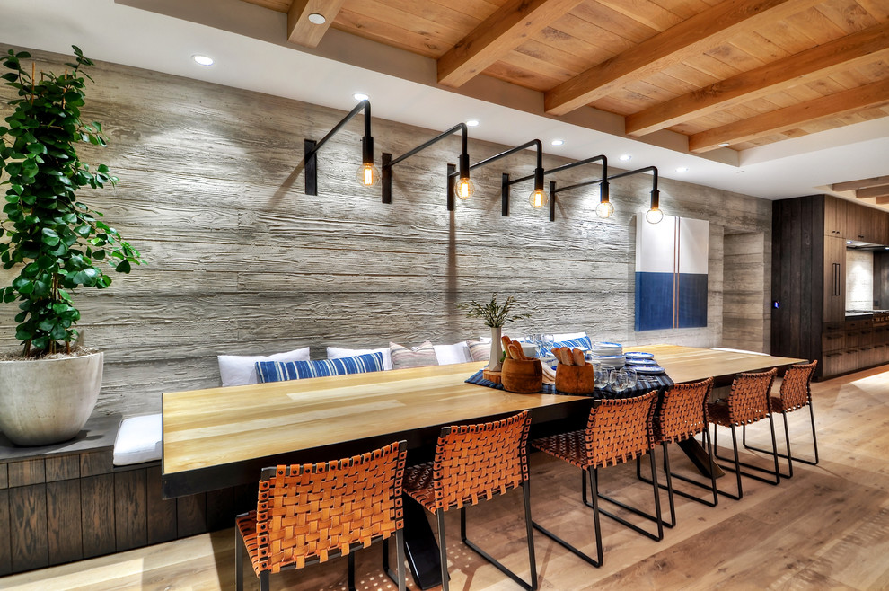 Modern kitchen/dining room in Orange County with grey walls and medium hardwood flooring.