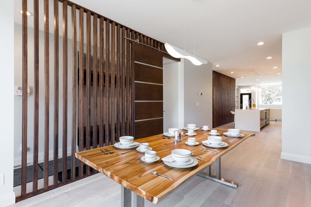 На фото: кухня-столовая среднего размера в современном стиле с белыми стенами и светлым паркетным полом