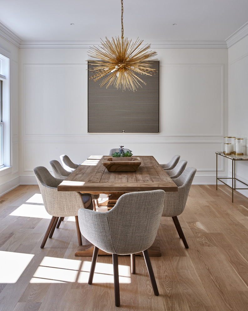 Foto di una sala da pranzo minimal con pareti bianche, pavimento in legno massello medio e pavimento marrone