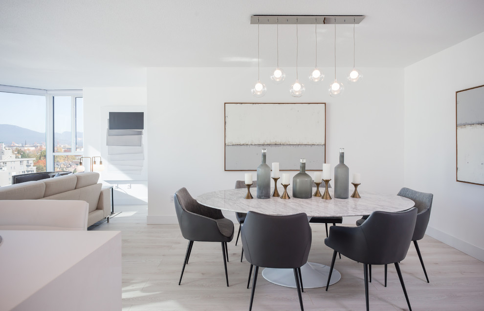 Immagine di una sala da pranzo contemporanea con pareti bianche, parquet chiaro e pavimento beige