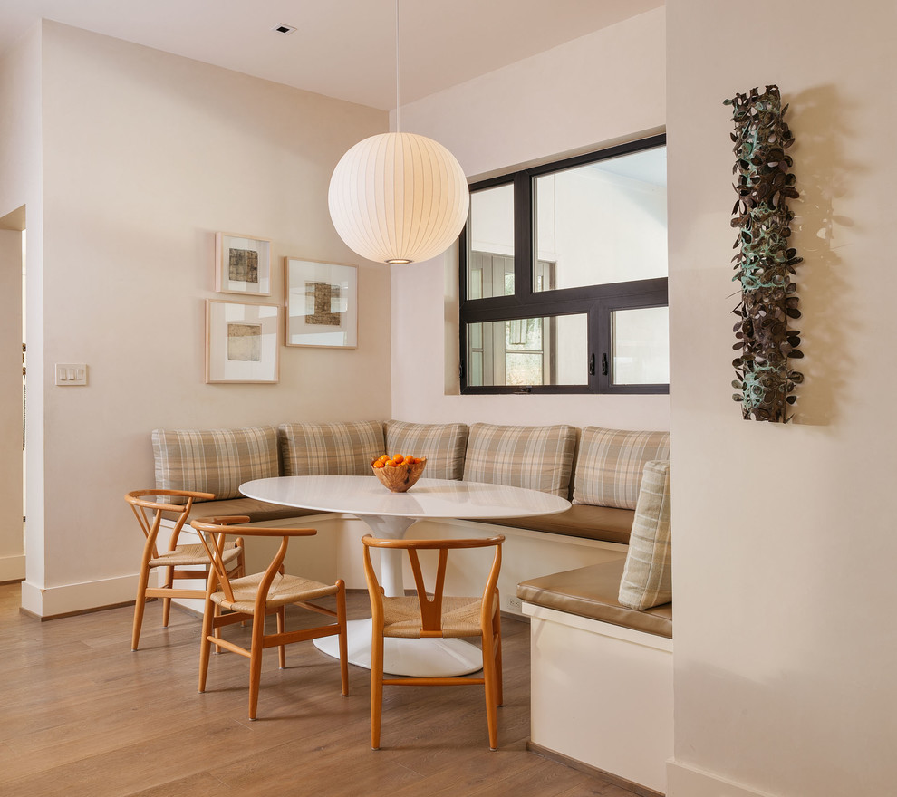 Immagine di una sala da pranzo minimal con pareti beige e parquet chiaro