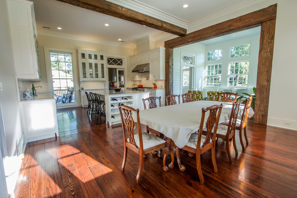 Foto di una grande sala da pranzo aperta verso la cucina tradizionale con pareti bianche, pavimento in legno massello medio e nessun camino