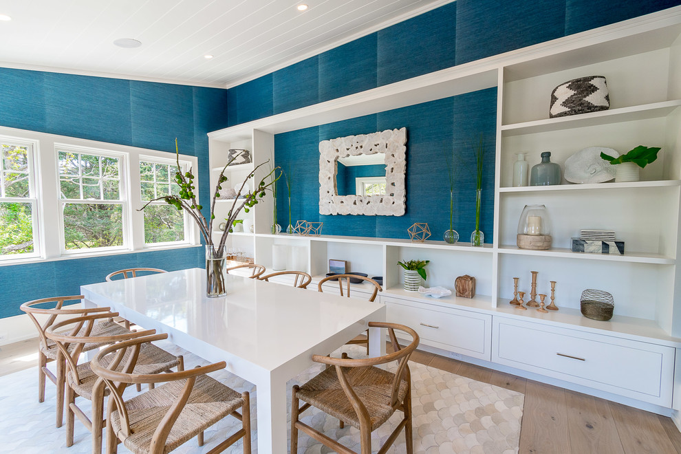 Diseño de comedor costero cerrado con paredes azules, suelo de madera clara y suelo beige