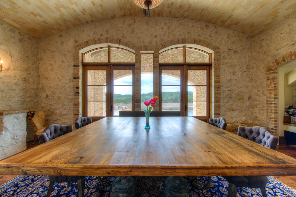 Immagine di una sala da pranzo aperta verso la cucina mediterranea con parquet chiaro e camino bifacciale