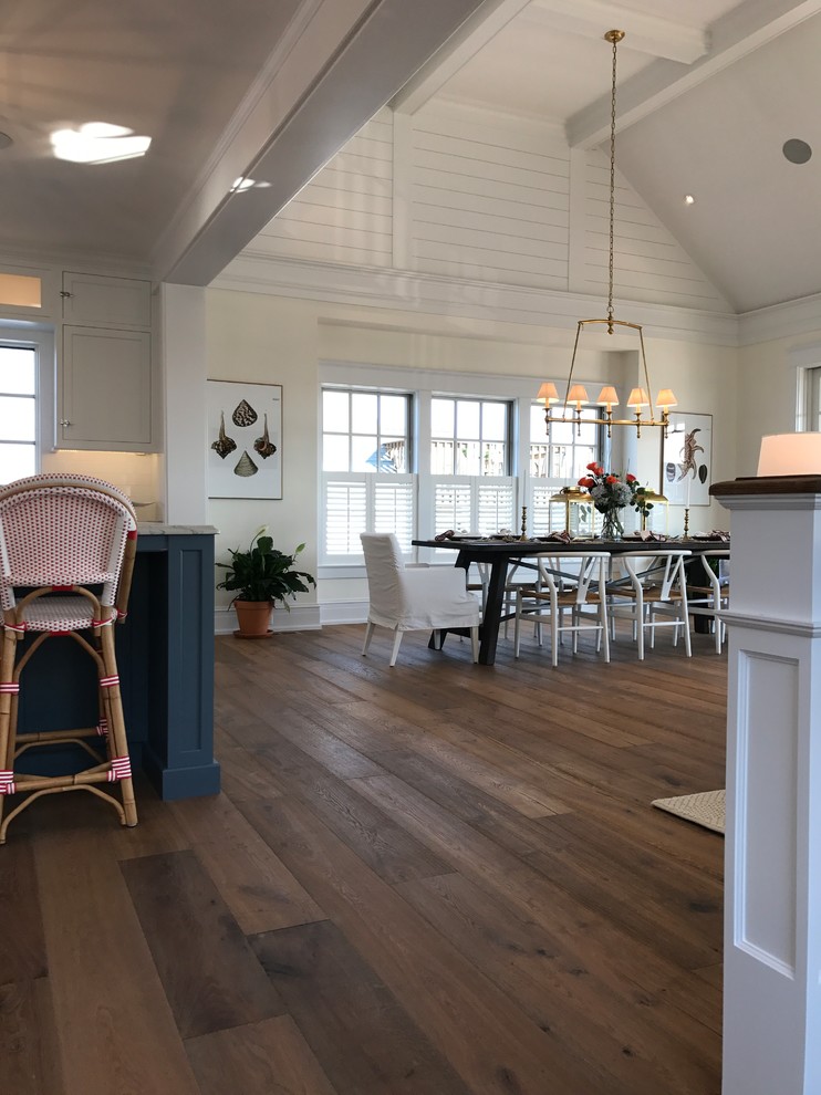Foto di una sala da pranzo aperta verso il soggiorno costiera di medie dimensioni con pareti beige, pavimento in legno massello medio e pavimento marrone