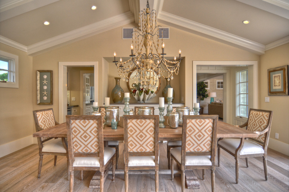 Inspiration for a beach style dining room in Los Angeles with beige walls, dark hardwood flooring and feature lighting.