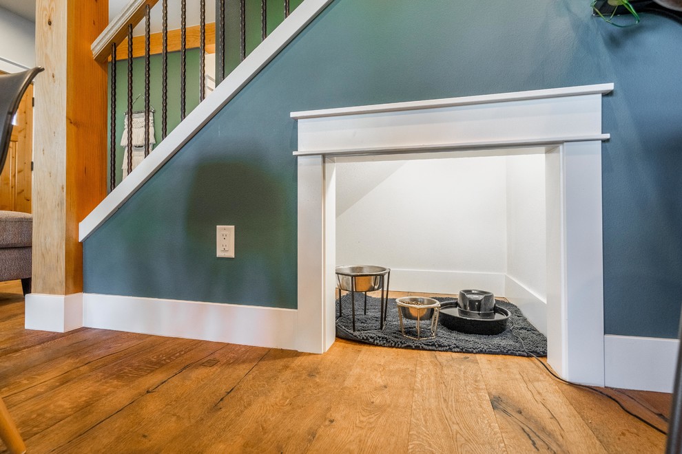 Cette photo montre une petite salle à manger ouverte sur le salon craftsman avec un mur vert, un sol en bois brun et un sol marron.