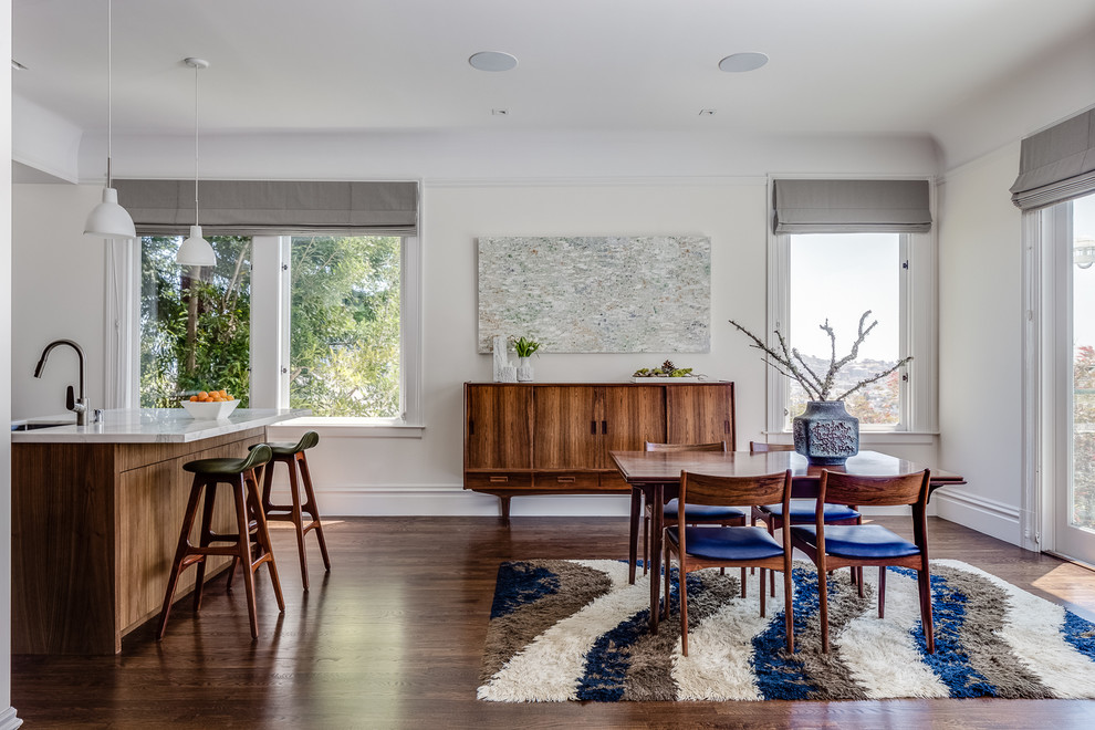 This is an example of a contemporary kitchen/dining room in San Francisco with white walls, dark hardwood flooring and no fireplace.