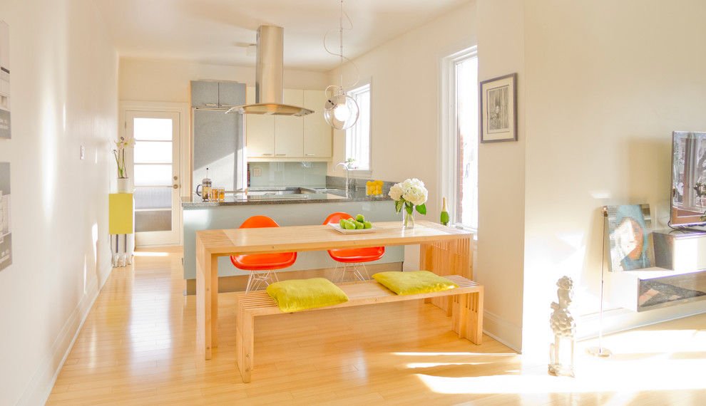 Exemple d'une salle à manger ouverte sur la cuisine tendance de taille moyenne avec un mur blanc et parquet en bambou.
