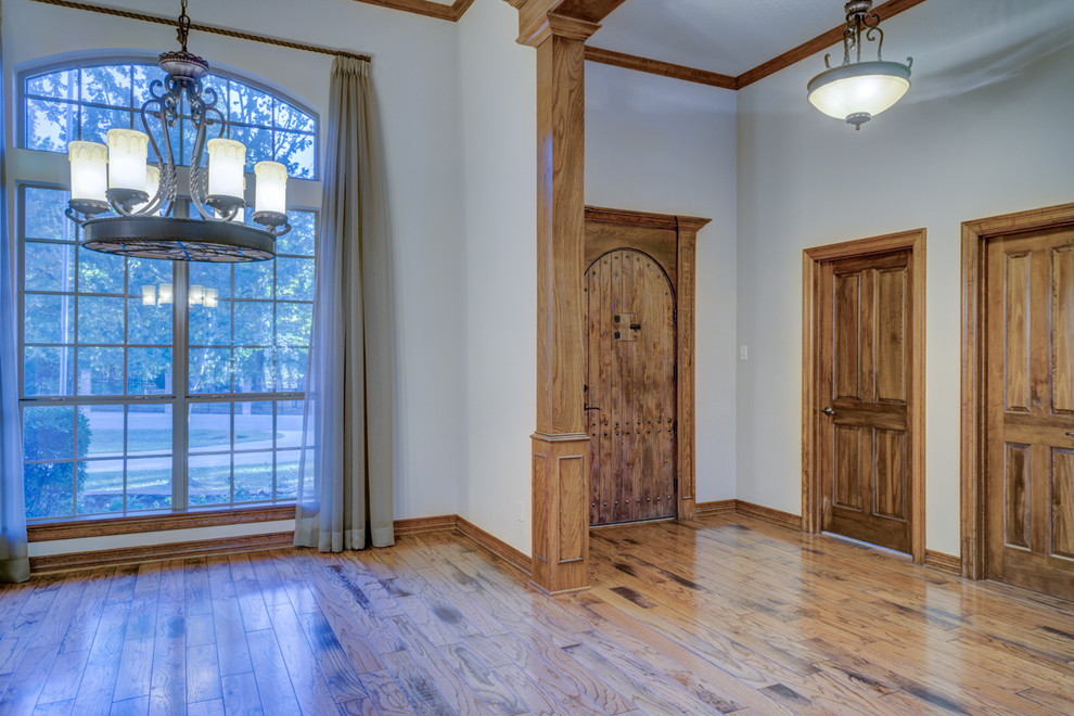 Esempio di una sala da pranzo aperta verso il soggiorno chic di medie dimensioni con pareti beige e pavimento in legno massello medio