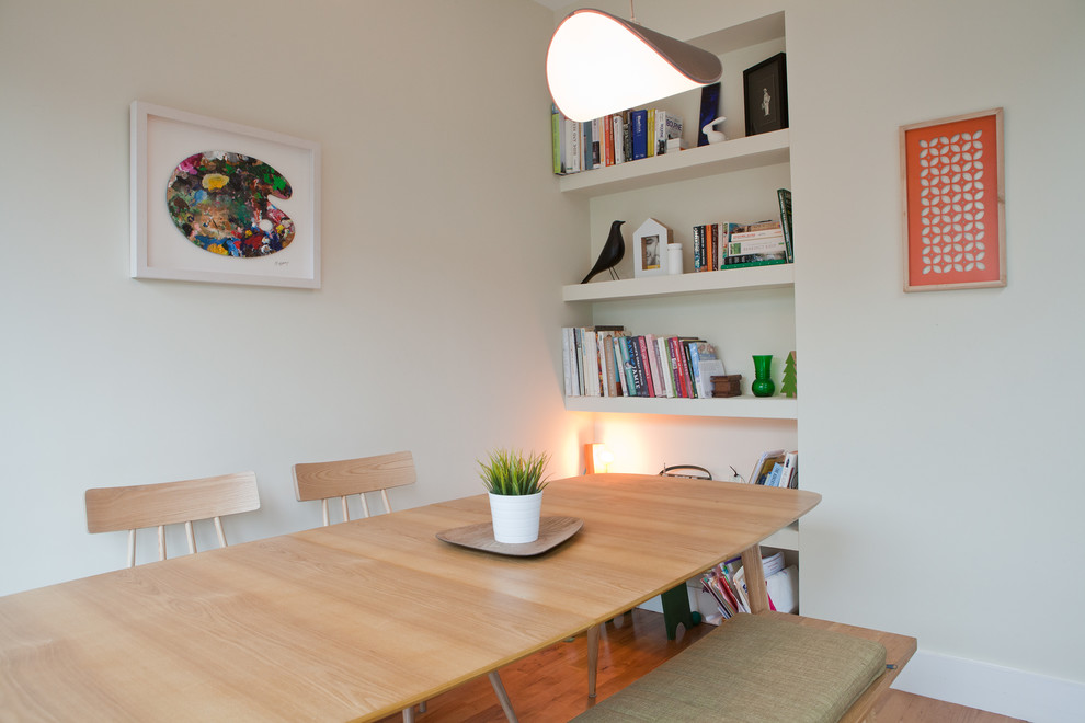 На фото: отдельная столовая в современном стиле с белыми стенами и светлым паркетным полом