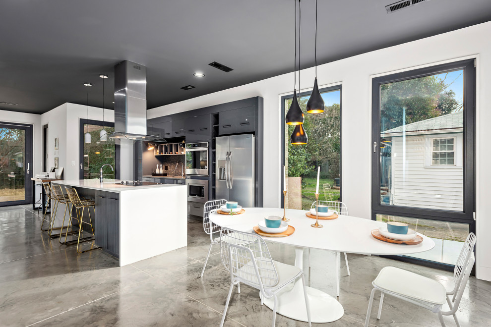 Идея дизайна: кухня-столовая среднего размера в стиле модернизм с белыми стенами, бетонным полом и серым полом