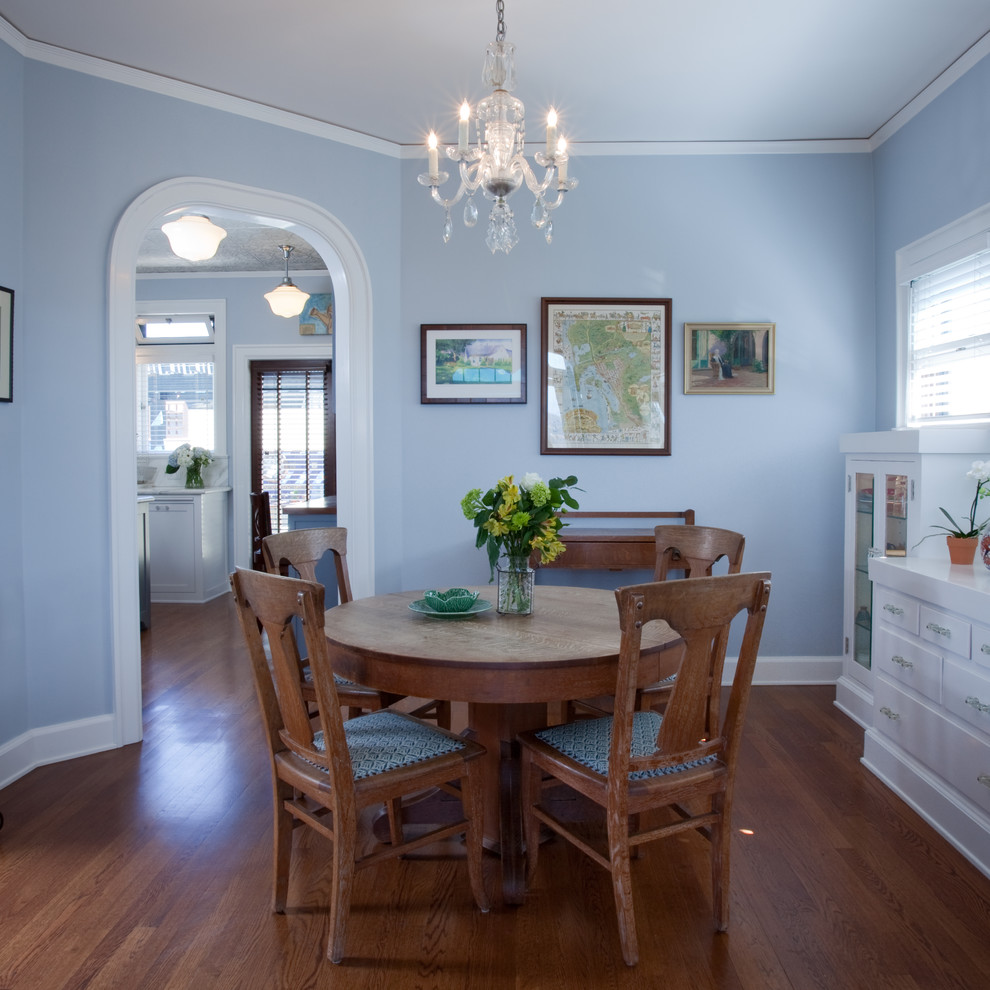 Example of an eclectic medium tone wood floor enclosed dining room design in San Diego with blue walls and no fireplace