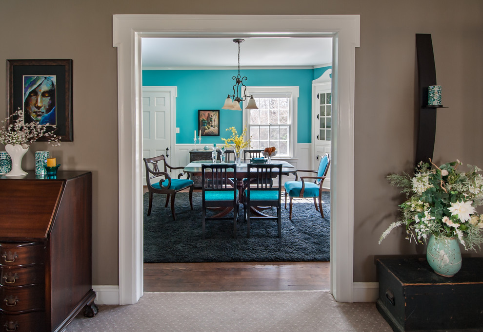 Cette image montre une salle à manger bohème fermée et de taille moyenne avec un mur bleu et parquet foncé.
