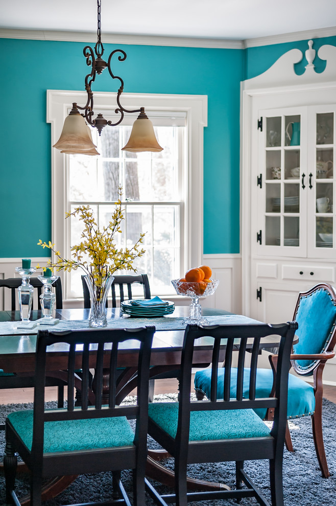Esempio di una sala da pranzo boho chic chiusa e di medie dimensioni con pareti blu e parquet scuro
