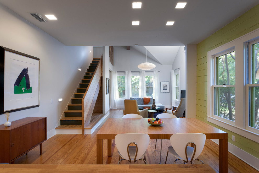 Modernes Esszimmer mit grüner Wandfarbe und braunem Holzboden in Austin