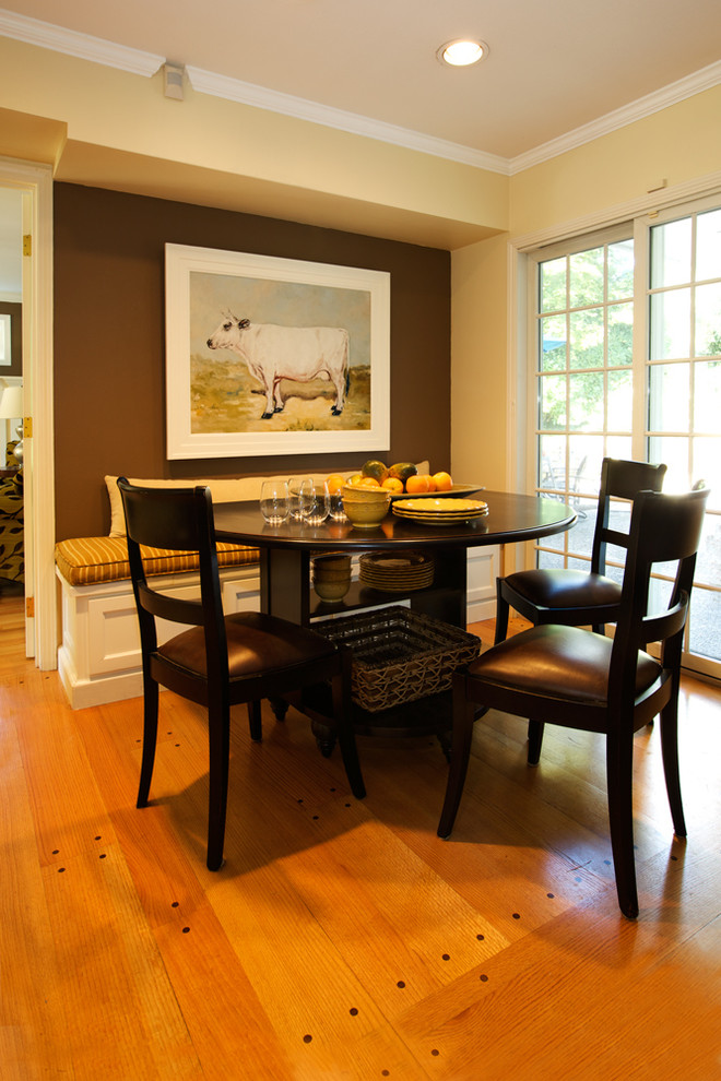 На фото: столовая в классическом стиле с коричневыми стенами и паркетным полом среднего тона с