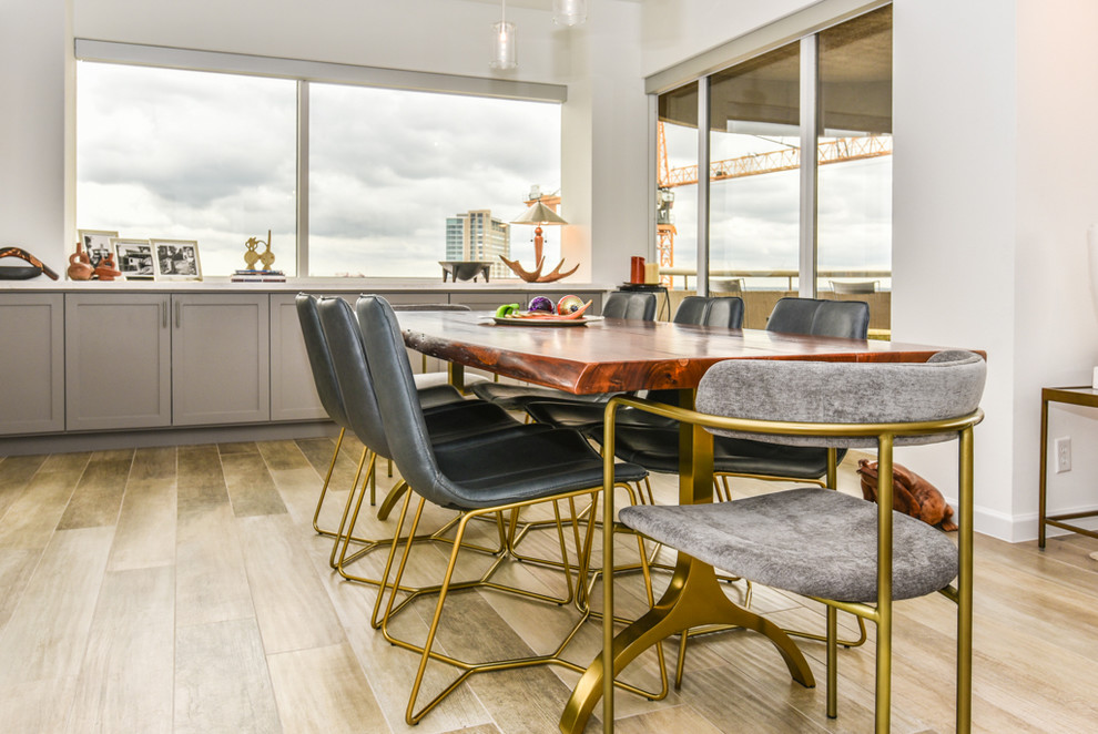Ispirazione per una sala da pranzo aperta verso il soggiorno minimal di medie dimensioni con pareti bianche, pavimento in gres porcellanato e pavimento marrone