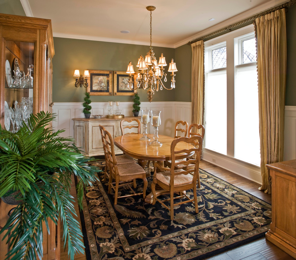 Geschlossenes Klassisches Esszimmer mit grüner Wandfarbe und braunem Holzboden in Grand Rapids