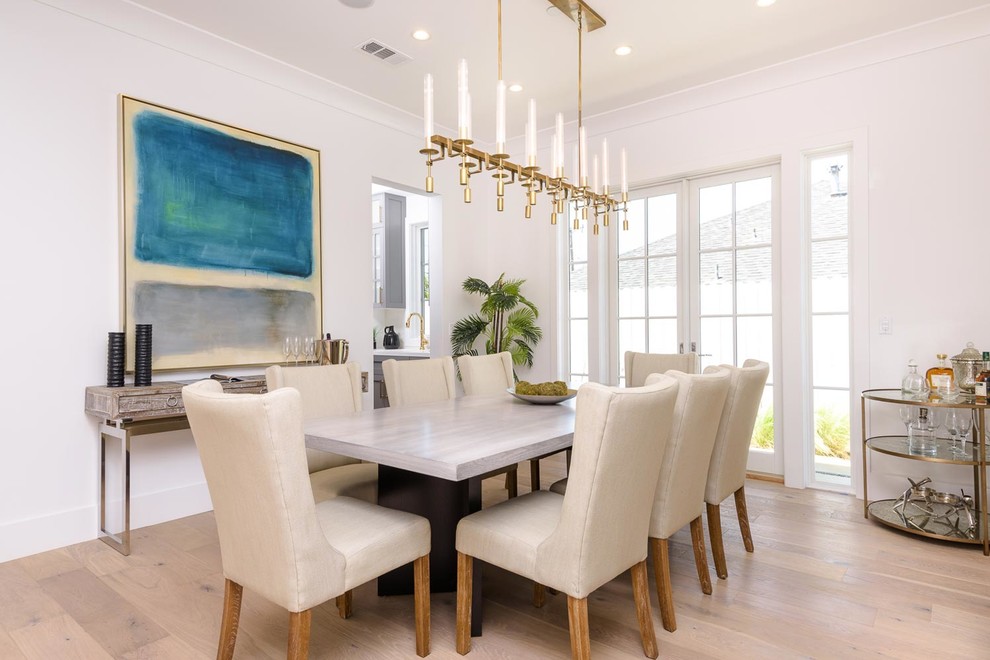 Dining room - transitional light wood floor and beige floor dining room idea in Los Angeles with white walls