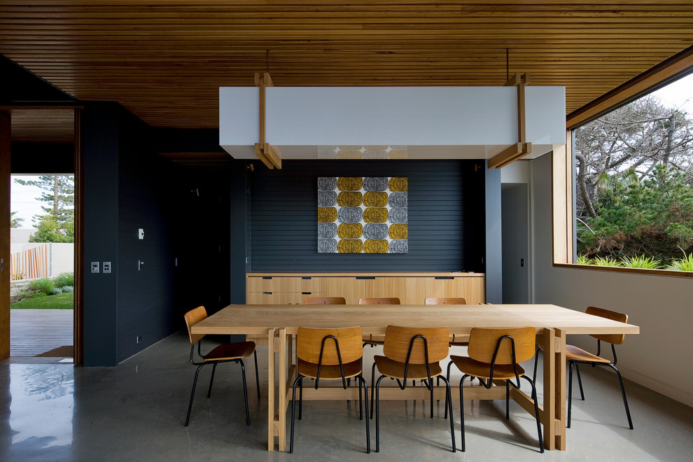 Idée de décoration pour une salle à manger design avec sol en béton ciré.