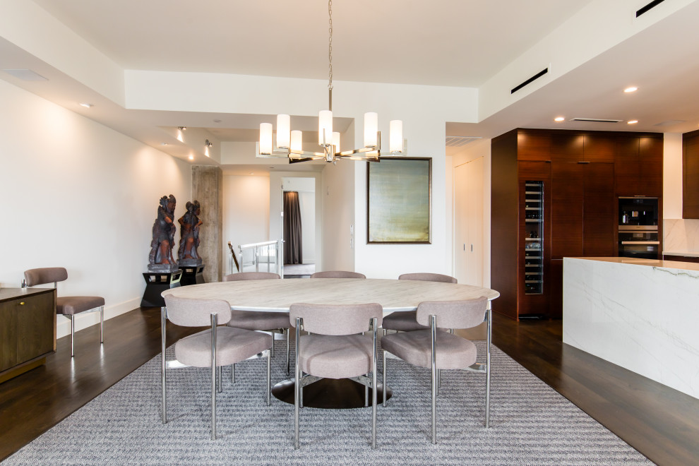 Foto di una sala da pranzo aperta verso il soggiorno minimalista di medie dimensioni con pareti bianche, parquet scuro e pavimento marrone