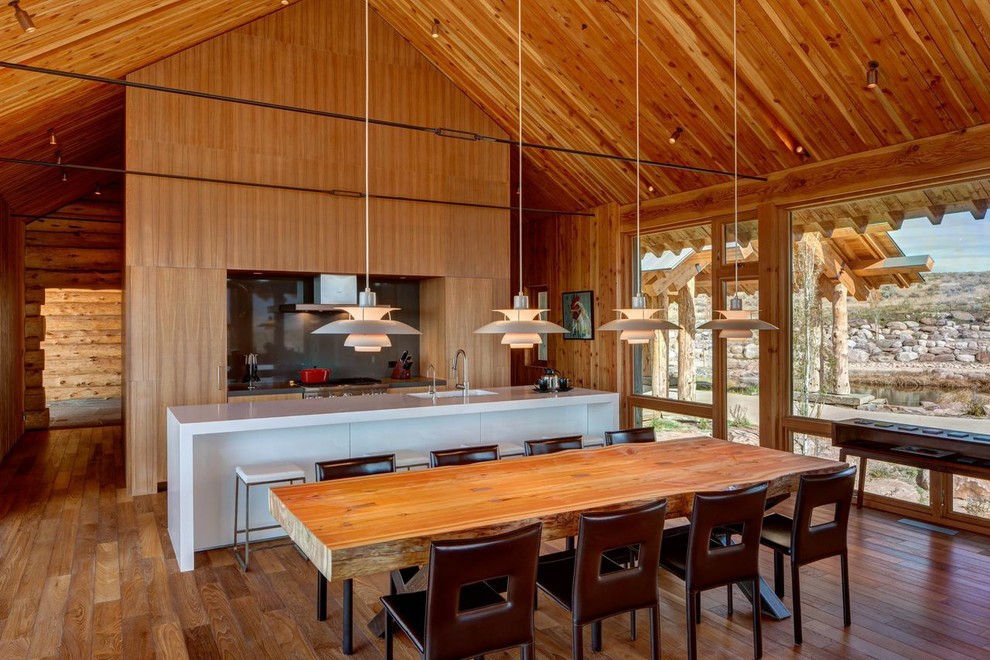 Exemple d'une salle à manger ouverte sur le salon montagne de taille moyenne avec un sol en bois brun et aucune cheminée.