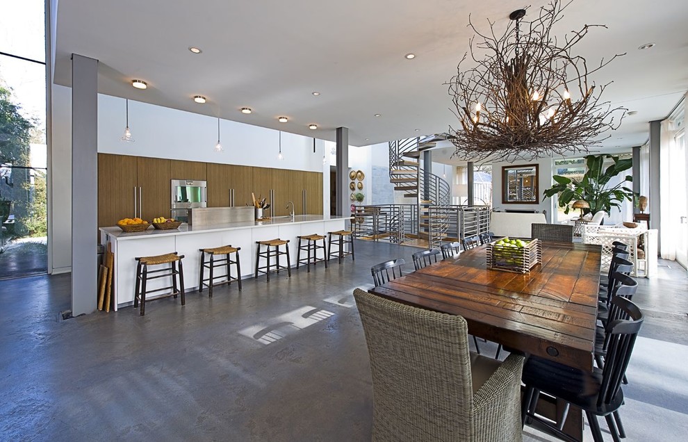 Idée de décoration pour une salle à manger design avec sol en béton ciré et un mur blanc.