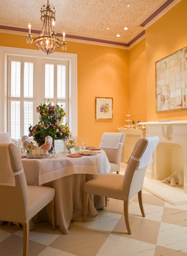 Idées déco pour une salle à manger ouverte sur le salon classique de taille moyenne avec parquet peint, une cheminée standard, un manteau de cheminée en plâtre et un mur jaune.