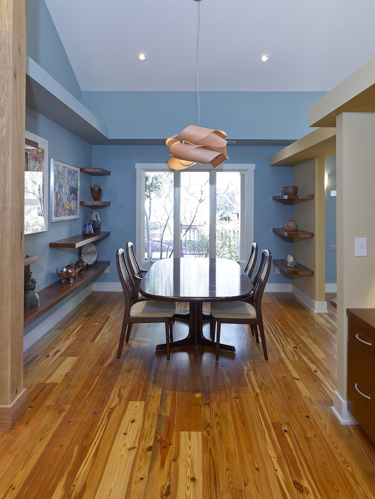 Idée de décoration pour une salle à manger ouverte sur le salon design de taille moyenne avec un mur bleu et parquet clair.