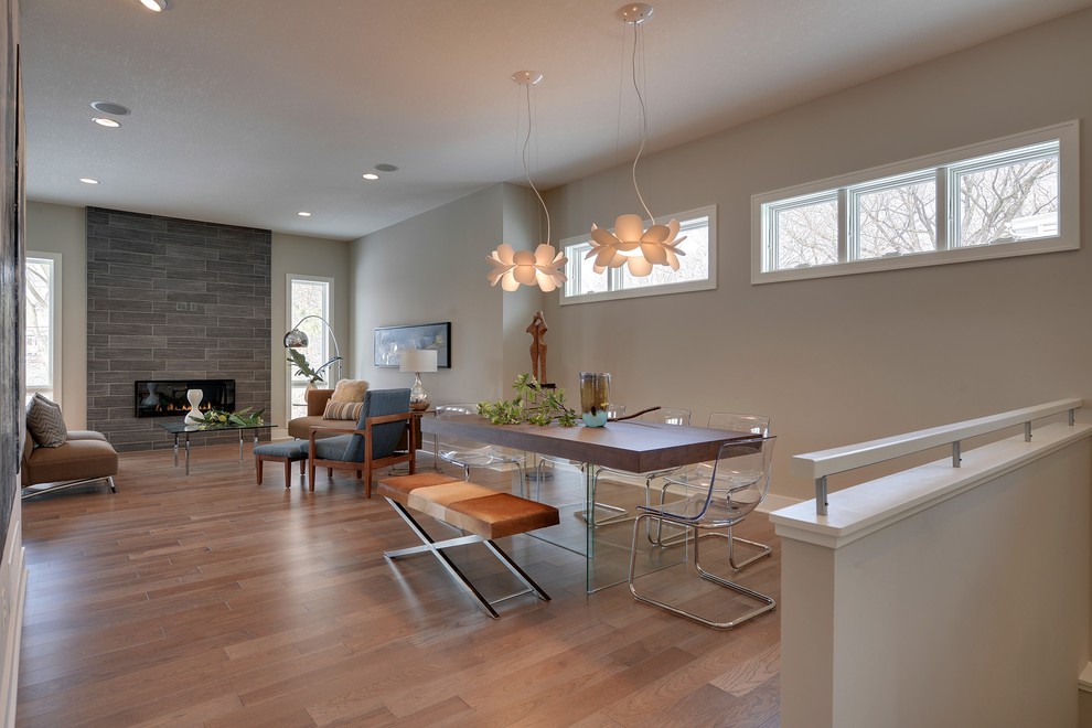 Medium sized modern open plan dining room in Minneapolis with grey walls and a tiled fireplace surround.