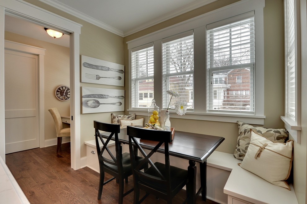 Cette image montre une salle à manger ouverte sur la cuisine traditionnelle avec un mur beige, parquet foncé et éclairage.