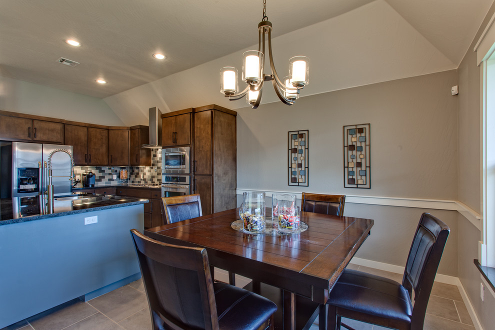 Cette image montre une salle à manger ouverte sur la cuisine minimaliste avec un mur gris, un sol en carrelage de céramique, une cheminée standard et un manteau de cheminée en carrelage.