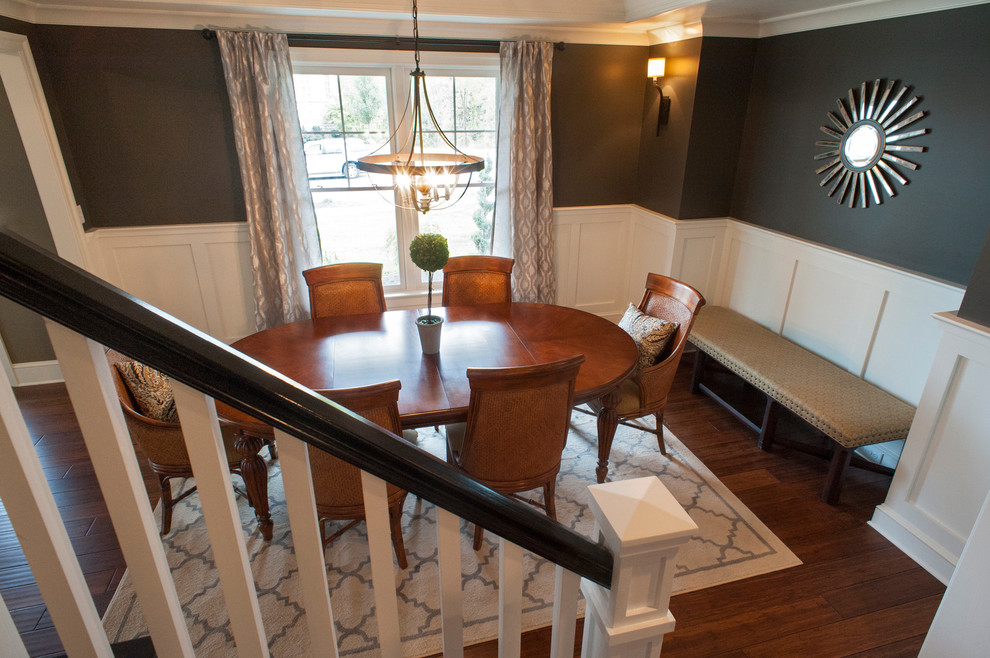 Example of a mid-sized transitional medium tone wood floor enclosed dining room design in Other with gray walls