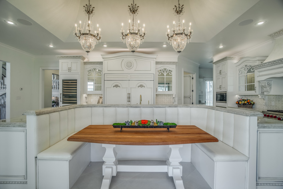 Cette photo montre une très grande salle à manger ouverte sur la cuisine chic avec un mur blanc.