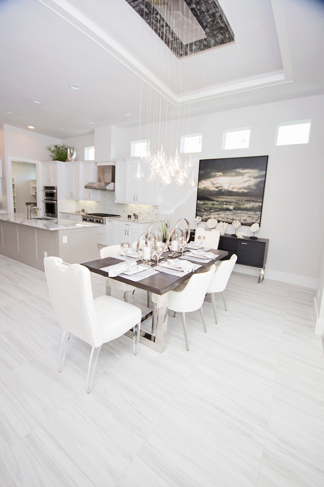 Large modern kitchen/dining room in Miami with white walls and marble flooring.
