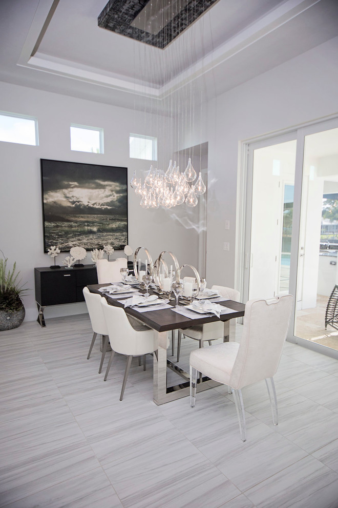 Idée de décoration pour une grande salle à manger ouverte sur la cuisine minimaliste avec un mur blanc et un sol en marbre.