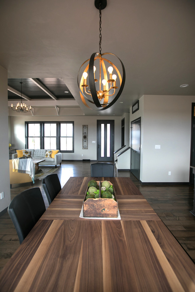 Esempio di una sala da pranzo aperta verso il soggiorno country con pareti beige, parquet scuro e pavimento beige