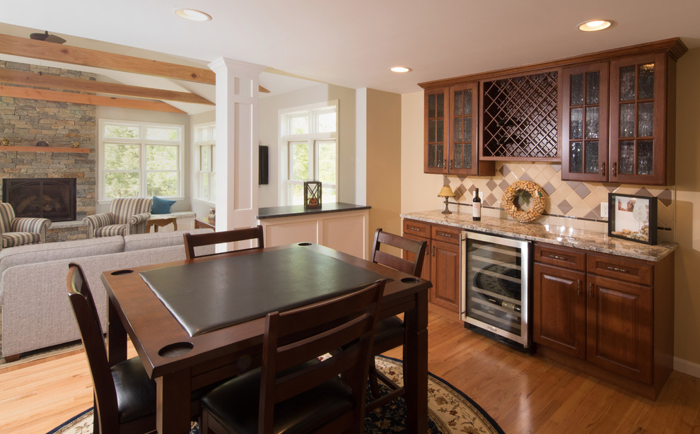 Aménagement d'une salle à manger ouverte sur la cuisine classique de taille moyenne avec un mur blanc, un sol en bois brun, une cheminée standard et un manteau de cheminée en pierre.